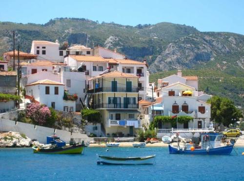 a group of houses and boats in the water at Achinos Apartments and Maisonettes in Kokkari
