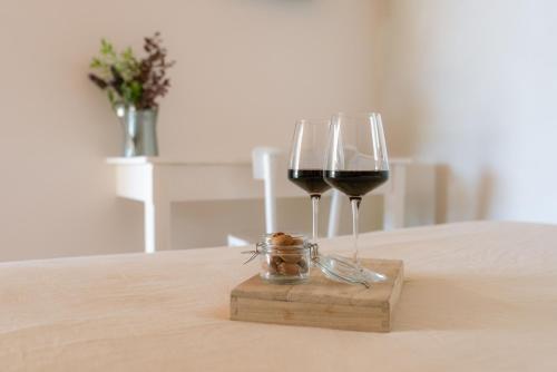 a couple of glasses of wine on a table at OrtoPì Country Canapa House in Porto Recanati