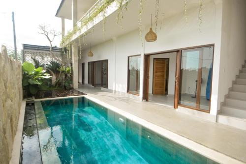 une piscine intérieure d'eau bleue dans une maison dans l'établissement Three Palms Surf & Stay Medewi, à Airsatang