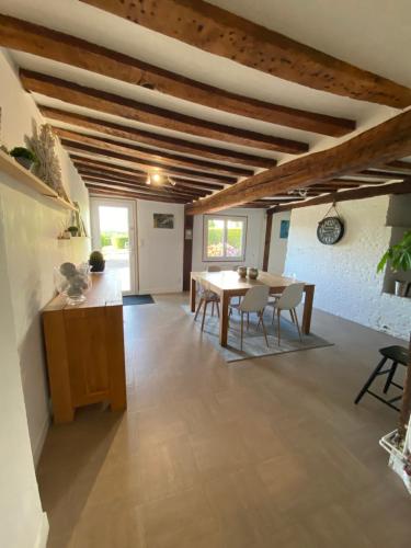 a kitchen and dining room with a table and chairs at La Ferrière in Pissy-Pôville