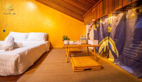 Habitación con 2 camas y mesa. en Flypod . Kinabalu Mt Lodge en Ranau