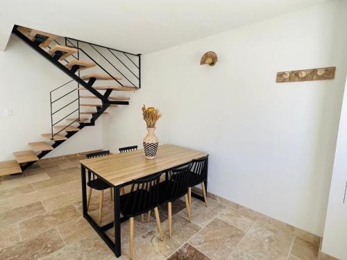 une salle à manger avec une table et un escalier dans l'établissement Résidence L’Oiseau des Sables, à Saintes-Maries-de-la-Mer