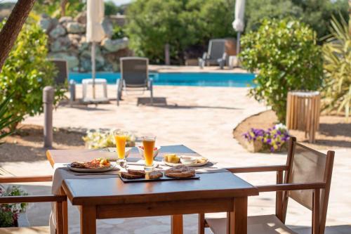 uma mesa com comida e bebidas junto a uma piscina em Agroturismo Son Juaneda em Ciutadella