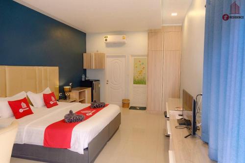 a bedroom with a large bed with red pillows at tt Residence in Chachoengsao