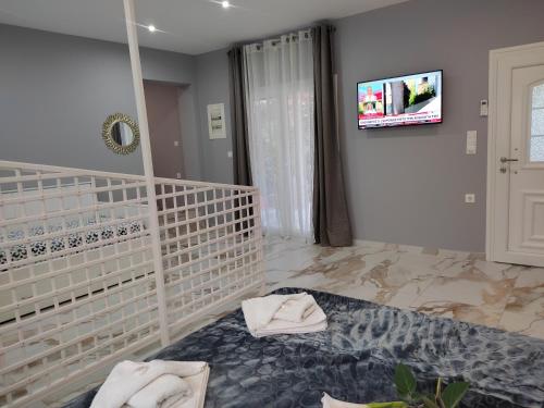 ein Zimmer mit einem Bett und einem Fernseher an der Wand in der Unterkunft Pefkari Bay Villas in Pefkari