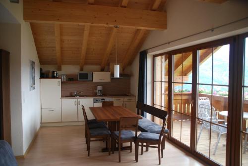 a kitchen and dining room with a table and chairs at Apart Acasa in Fiss