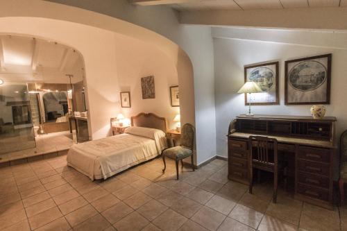 a bedroom with a bed and a vanity and a mirror at Finca Villa Juan in Ribera del Fresno