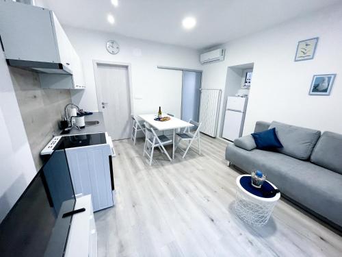 uma cozinha e sala de estar com um sofá e uma mesa em APARTMA GALEB em Piran