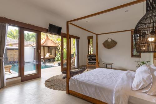 ein Schlafzimmer mit einem Bett und Blick auf einen Pool in der Unterkunft Villa Casa Orana in Seminyak