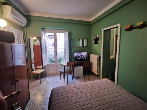 1 dormitorio con paredes verdes, 1 cama y escritorio en Casa Farella B&B in mini Apartments Altamura x Matera, en Altamura