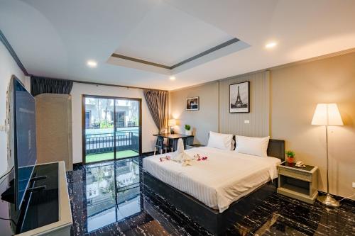 a hotel room with a bed and a large window at DEL MAX Resort Pattaya in Pattaya South
