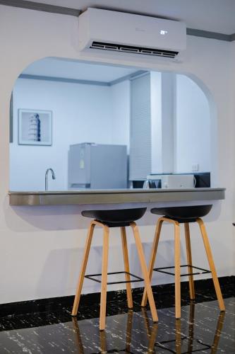 a kitchen with two bar stools under a counter at DEL MAX Resort Pattaya in Pattaya South