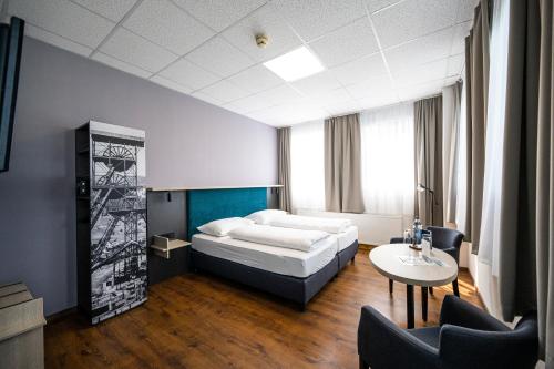 um quarto com uma cama, uma mesa e cadeiras em Hotel Fohnsdorf em Fohnsdorf