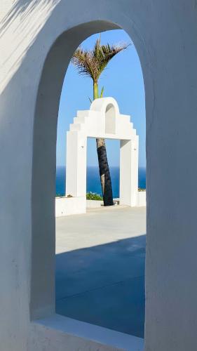 an archway with a palm tree and the ocean at Santorini Guesthouse in Amanzimtoti