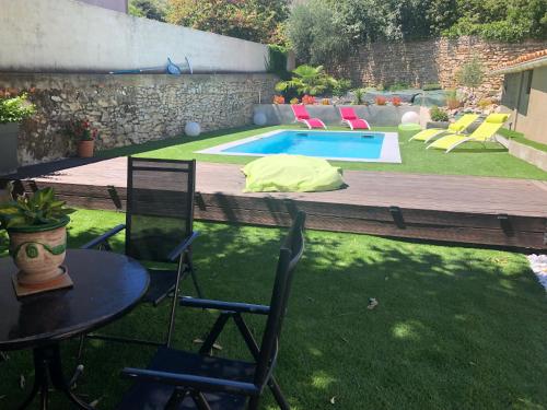une cour avec une table et des chaises ainsi qu'une piscine dans l'établissement Villa calme avec piscine privée nimes, à Nîmes