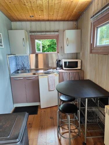 - une petite cuisine avec une table dans une petite maison dans l'établissement Chalet, à Torcé-en-Charnie
