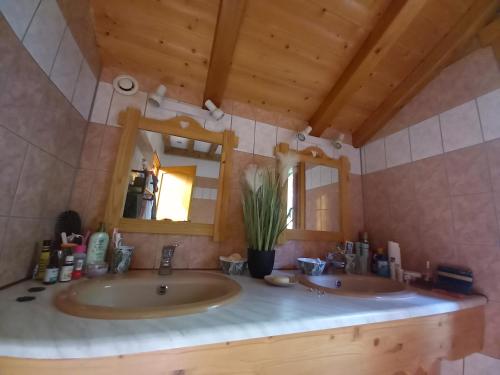 a bathroom with two sinks and a mirror at Chalet Typique Vosgien "les Barbotines" in Ventron