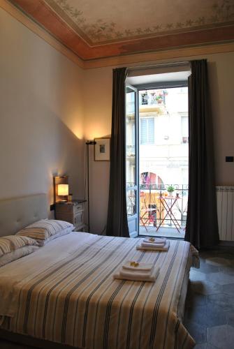 a bedroom with a large bed and a large window at Borromini Home in Turin