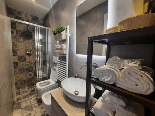 a bathroom with a toilet and a sink with towels at Borromini Home in Turin