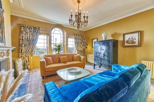 a living room with a blue couch and a table at River View Characterful Riverside Retreat in Berwick-Upon-Tweed