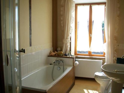 Un baño con bañera, inodoro y lavabo. en La Châtaigne Dorée, en Saint-Pierre-de-Fursac