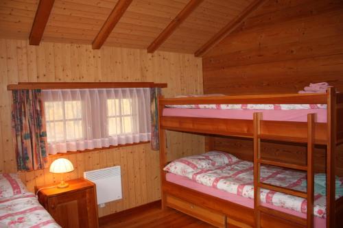 ツェルマットにあるChalet Zwächtaの窓付きのキャビン内の二段ベッド2台