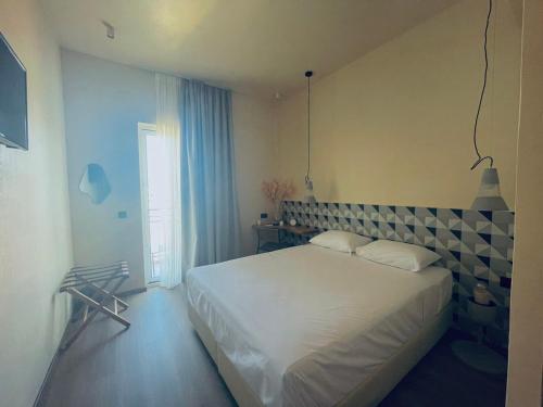 a bedroom with a white bed and a window at 193 Urban Hotel in Patra