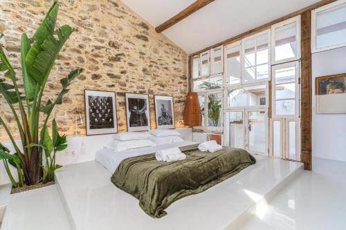een slaapkamer met een groot bed en een bakstenen muur bij Suites D´aldeia - Suite 16 in Mafra