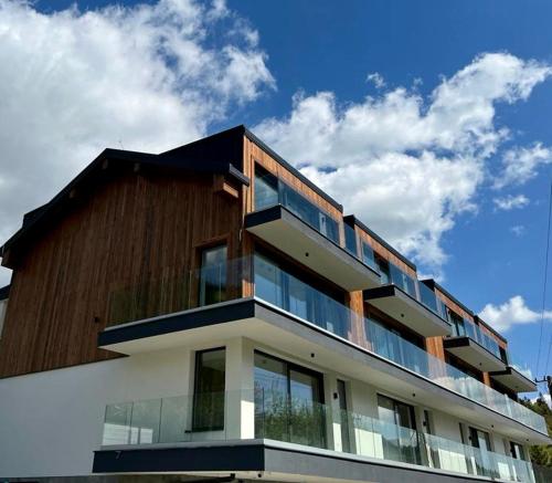 un edificio con balcones de cristal encima en Apartament Sevilla z prywatną sauną, en Szczyrk