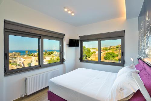 um quarto com 2 janelas e uma cama com vista em Mini Maisonette em Stalos