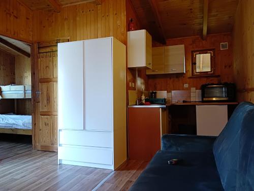 a kitchen with a white refrigerator in a room at Domki Letniskowe Oaza Wicie in Wicie