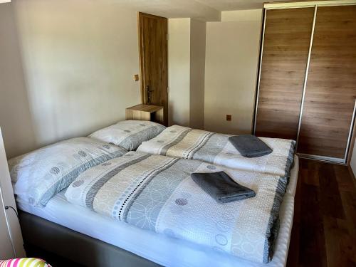 a bed with two pillows on it in a bedroom at EDER- Penzion & Apartmány in Horní Planá