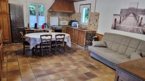 a kitchen with a table and a couch in a room at Gîte à la ferme à Quend baie de Somme in Quend