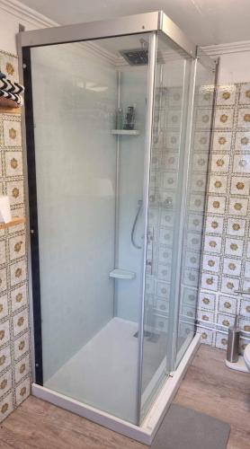 a shower with a glass door in a room at Gîte à la ferme à Quend baie de Somme in Quend