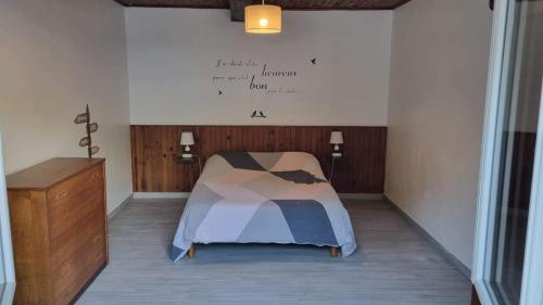 a bedroom with a bed and a wall with writing on the wall at Gîte à la ferme à Quend baie de Somme in Quend