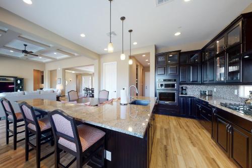 a kitchen with a large island with bar chairs at Dove Mountain Dream in Marana
