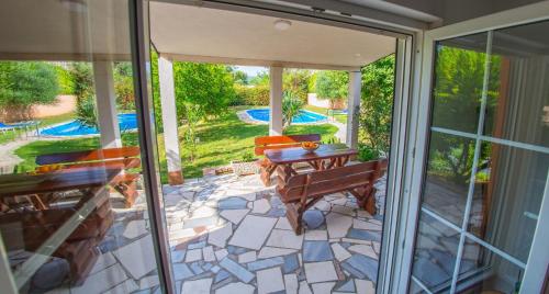 um pátio aberto com uma mesa e um banco num pátio em Holiday Home Narona em Mostar