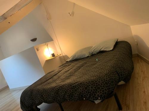 ein Schlafzimmer mit einem Bett mit einer schwarzen Bettdecke in der Unterkunft Charmant duplex de 28m2 en plein centre ville in Tarbes