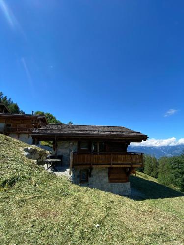 a building on top of a hill next to a field at Bishorn COSY chalet 4 personnes in Les Collons