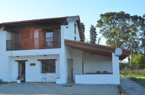 una casa con un balcón en el lateral. en Rural Norte, en Bañugues