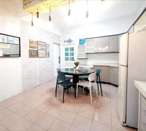 a kitchen with a table and chairs and a refrigerator at 527 BeachHouse l 5 bedroom with swimming pool - 3min walk to the beach in Tanjung Bungah