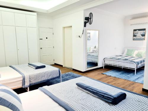 a bedroom with two beds and a mirror at 527 BeachHouse l 5 bedroom with swimming pool - 3min walk to the beach in Tanjung Bungah