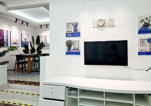 a living room with a tv on a wall at 527 BeachHouse l 5 bedroom with swimming pool - 3min walk to the beach in Tanjung Bungah