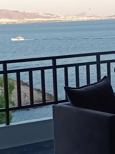 a couch sitting on a balcony looking out at the water at Blue Seaview Suites in Piraeus