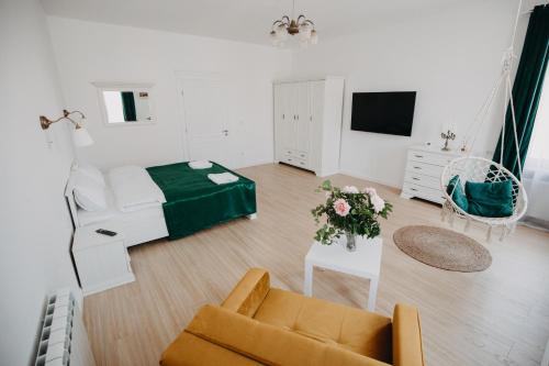 a white living room with a couch and a tv at Studio Manzur in Braşov