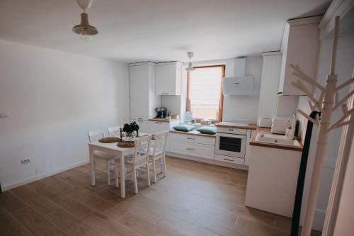 a kitchen with white cabinets and a table and chairs at Studio Manzur in Braşov