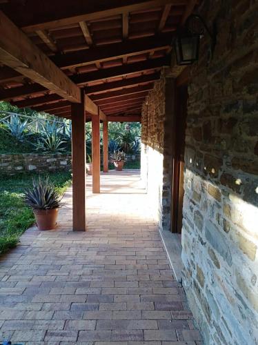 a patio with a stone wall and a wooden roof at Casa vacanze Il Mandorlo in Perdifumo