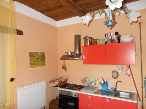 a kitchen with a red cabinet and a sink at La Neviera Nel Pozzo in Offida