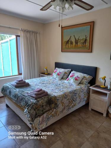 a bedroom with a bed with pillows on it at Whispering Gardens in Stilbaai
