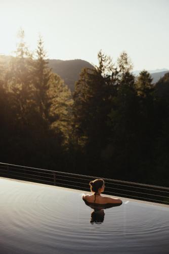 a person sitting in a body of water at Hotel Digon in Ortisei